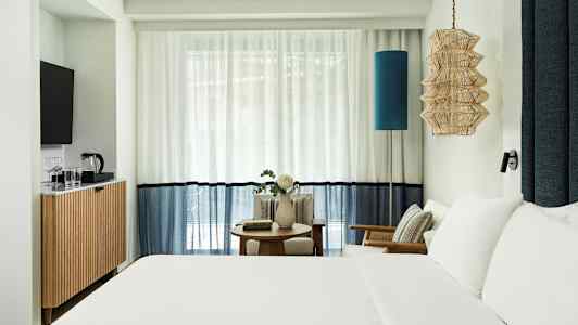 Hotellrom med dobbeltseng, sittemøbler og TV. (AI-generert tekst)