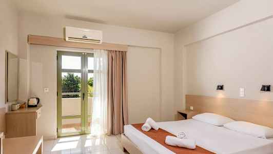 Et hotellrom med en dobbeltseng, to nattbord og en uteplass med lyse gardiner. (AI-generert tekst)