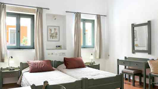 Bilde av et lyst soverom med to enkeltsenger, vinduer med lys innslipp og møbler i tre. (AI-generert tekst)