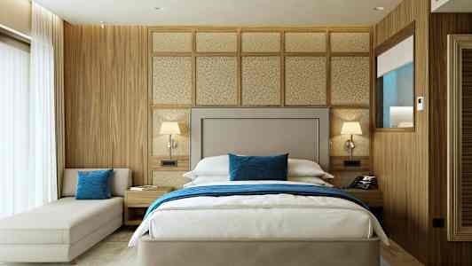 Interiør av et hotellrom med en dobbeltseng, nattbord og moderne innredning. (AI-generert tekst)