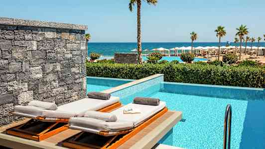 Solstoler ved et privat basseng med havutsikt. (AI-generert tekst)