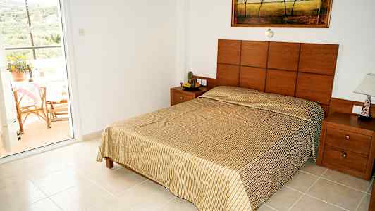 Soverom med en dobbeltseng og utsikt mot en balkong. (AI-generert tekst)