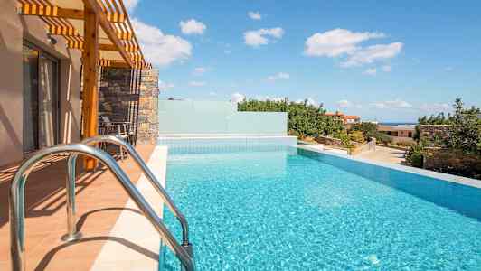 Et infinitybasseng ved et hus med solskinn og utsikt over grøntområder og himmel. (AI-generert tekst)