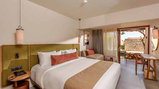 Et moderne hotellrom med en stor seng, komfortable møbler og en uteplass. (AI-generert tekst)