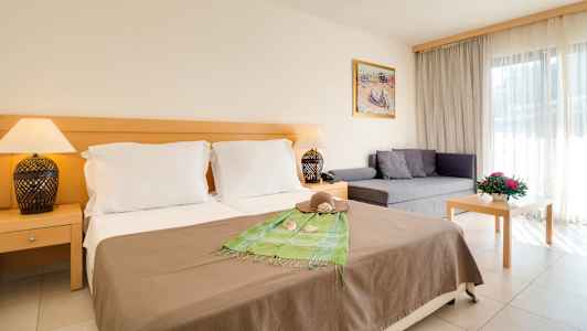 Hotellrom med dobbeltseng, sofa og bord. (AI-generert tekst)