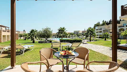 En sittegruppe med utsikt mot en frodig hage og et basseng. (AI-generert tekst)