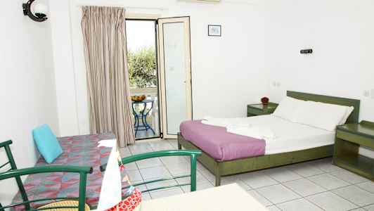 Et hotellrom med en dobbeltseng, en sofa, et bord med stoler og en balkong med utsikt. (AI-generert tekst)