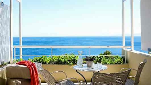 Balkong med utsikt over havet. (AI-generert tekst)