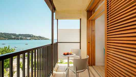 Balkong med utsikt over havet og et bord med frukt. (AI-generert tekst)