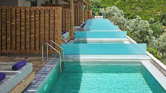 Privat bassenger med solsenger og utsikt over frodig natur. (AI-generert tekst)