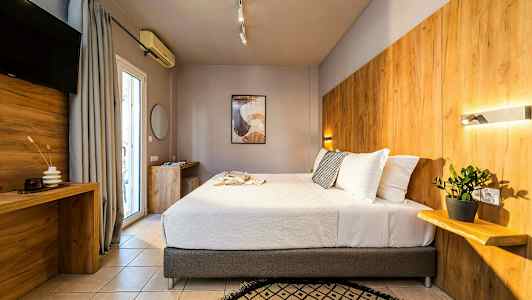 Et moderne hotellrom med en stor seng, trepaneler på veggen og en plante på en hylle. (AI-generert tekst)