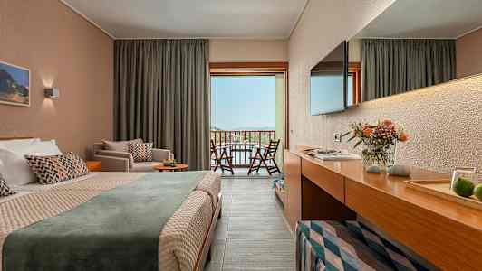 Et hotellrom med dobbeltseng og balkongutsikt over landskap. (AI-generert tekst)