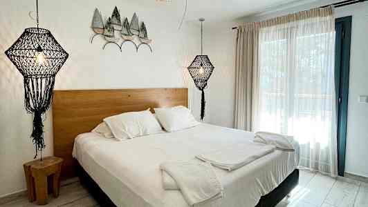 Soverom med dobbeltseng, hvitt sengetøy og dekorative lamper i moderne design. (AI-generert tekst)