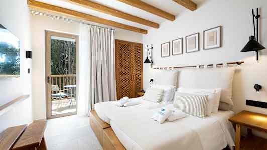 Et hotellrom med dobbeltseng, tredetaljer og moderne innredning. (AI-generert tekst)