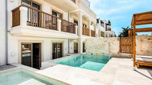 Bilde av en hotellbygning med private bassenger og solstoler ved terrasseområdet. (AI-generert tekst)