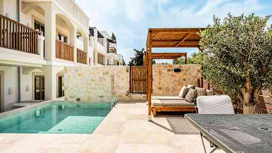 Hotellområde med et basseng, solsenger og pergola. (AI-generert tekst)