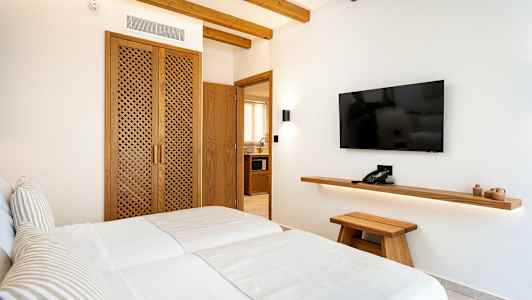 Bilde av et hotellrom med to enkeltsenger, tredetaljer og en veggmontert TV. (AI-generert tekst)