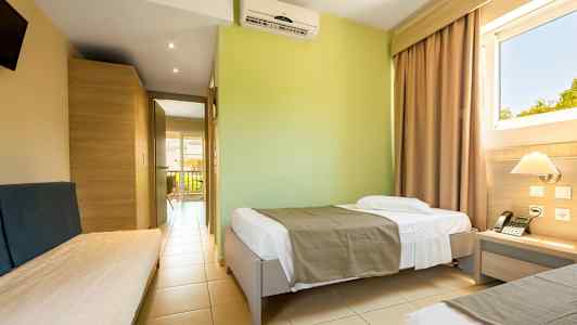 Et hotellrom med enkeltsenger og utsikt gjennom vinduet. (AI-generert tekst)