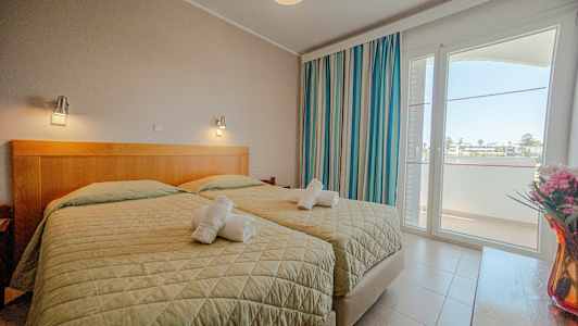 Et hotellrom med to enkeltsenger, vindu og dekorasjoner. (AI-generert tekst)