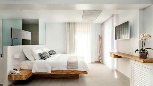 Moderne hotellrom med dobbeltseng og minimalistisk interiør. (AI-generert tekst)