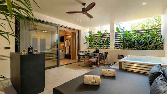 Privat terrasse med boblebad, sittegruppe og solseng. (AI-generert tekst)