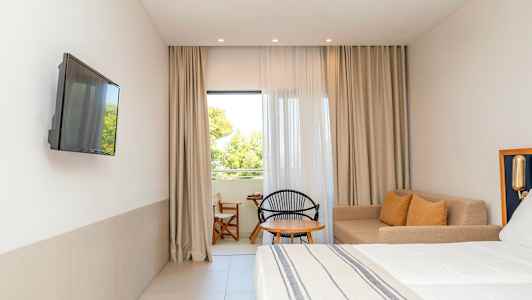 Hotellrom med sofakrok og seng. (AI-generert tekst)