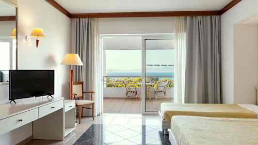 Interiør av et hotellrom med to senger, skrivebord og en uteplass med utsikt over havet. (AI-generert tekst)