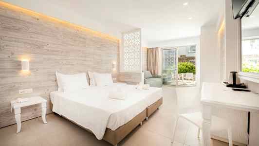 Moderne hotellrom med dobbeltseng, sittegruppe og balkong. (AI-generert tekst)