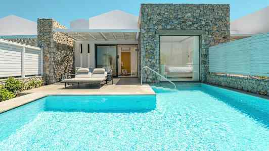 En villa med basseng og solsenger ved inngangen. (AI-generert tekst)