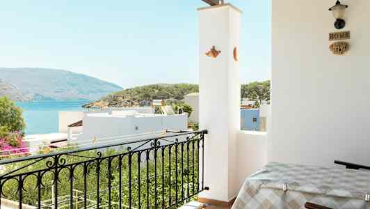 En balkong med utsikt over havet og det omkringliggende landskapet. (AI-generert tekst)