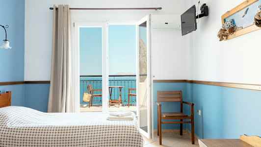 Hotellrom med to senger, utsikt mot en balkong og havet. (AI-generert tekst)