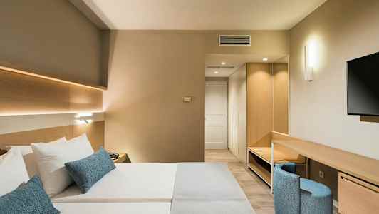 Moderne hotellrom med dobbeltseng, skrivebord og TV. (AI-generert tekst)