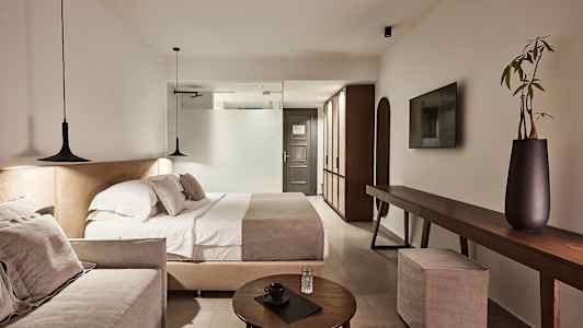 Et moderne hotellrom med dobbeltseng, sofa og elegant interiør. (AI-generert tekst)