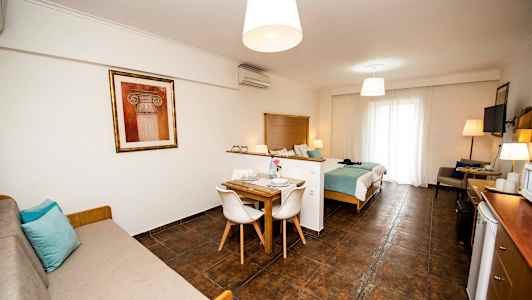 Et rom med sovested, spisebord og sofa. (AI-generert tekst)