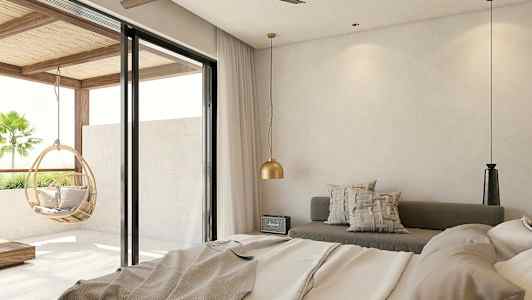 Et hotellrom med moderne design, med en seng, sitteplass og store glassdører som gir utsikt mot balkongen med en hengende kurvstol. (AI-generert tekst)