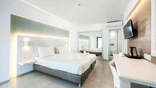 Moderne hotellrom med to senger, skrivebord og speil. (AI-generert tekst)