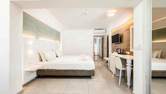 Et moderne hotellrom med en dobbeltseng, skrivebord og TV. (AI-generert tekst)