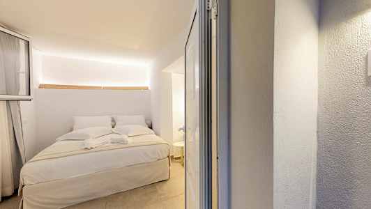 Et lyst soverominteriør med en oppredd dobbeltseng. (AI-generert tekst)