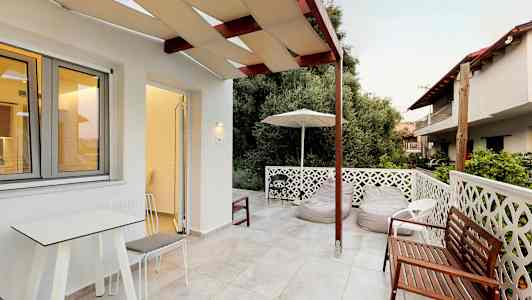 En terrasse med utemøbler og utsikt mot grøntområder. (AI-generert tekst)