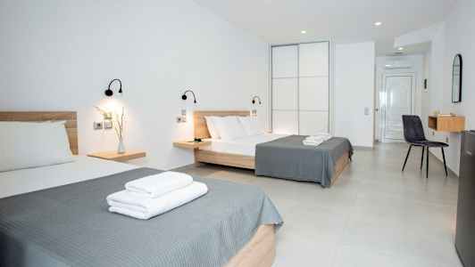 Hotellrom med to senger og moderne innredning. (AI-generert tekst)