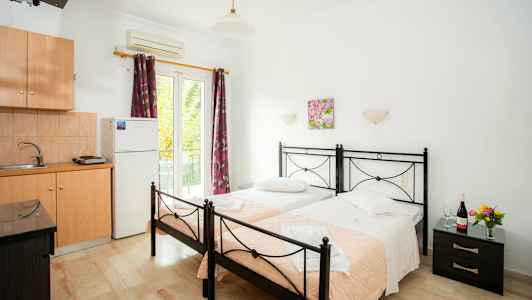 To enkeltsenger med rosa tepper i et rom med kjøkkenutstyr. (AI-generert tekst)