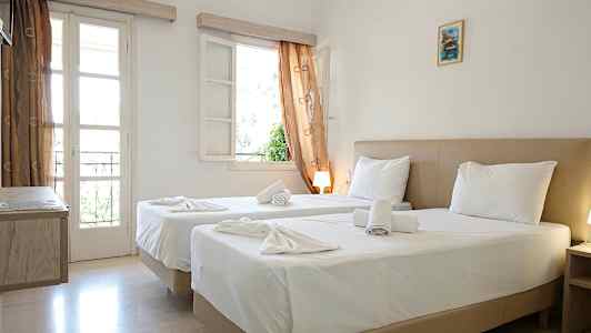 Et hotellrom med to senger, hvitt sengetøy og vinduer med gardiner. (AI-generert tekst)