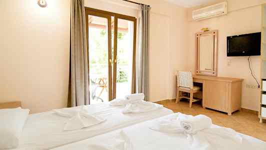 Hotellrom med to senger, skrivebord og TV. (AI-generert tekst)