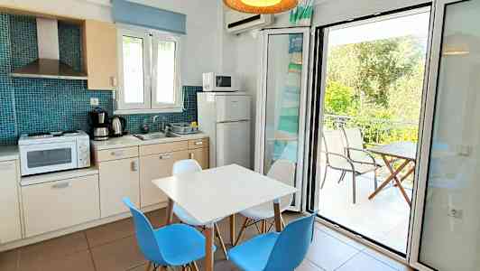 En leilighet med kjøkken, spiseplass og balkong. (AI-generert tekst)