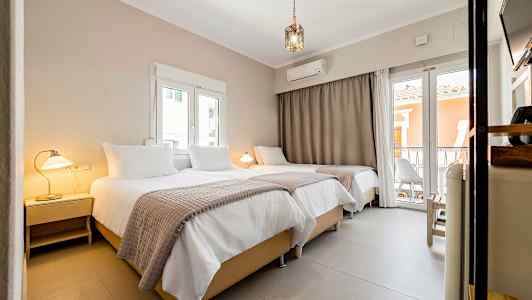 Interiør av et hotellrom med tre senger, lamper og vinduer. (AI-generert tekst)