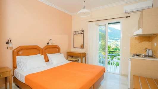 Hotellrom med oransje seng, skrivebord og balkong med utsikt. (AI-generert tekst)