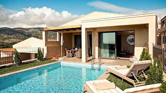 En villa med basseng og solsenger foran en naturskjønn utsikt. (AI-generert tekst)