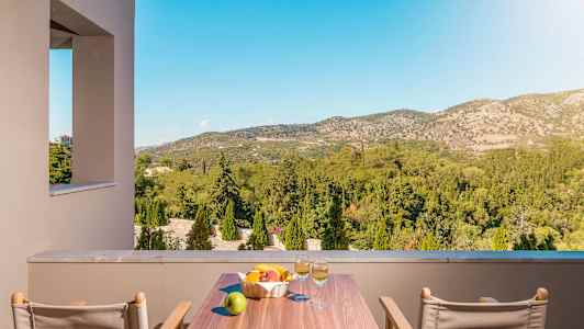 Utsikt fra en terrasse mot grønne åser og landskap. (AI-generert tekst)