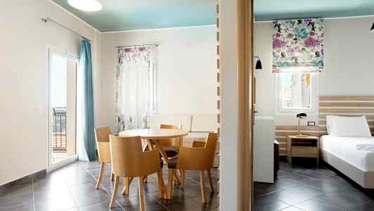 Moderne innredet hotellrom med spisebord, sitteplasser og seng. (AI-generert tekst)