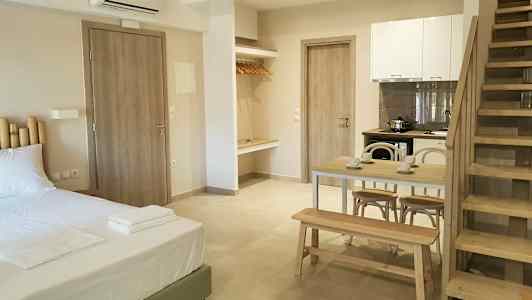 Et moderne rom med seng, spisebord, kjøkken og trapp. (AI-generert tekst)